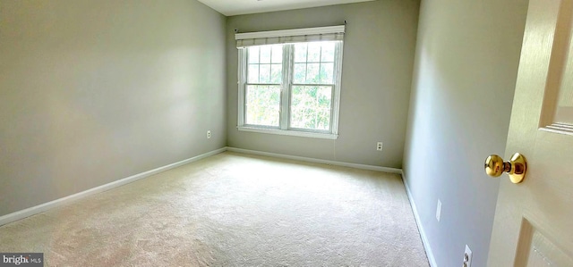 unfurnished room featuring carpet floors and baseboards