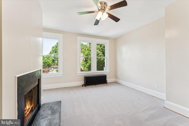 728 13th St SE, Washington, DC 20003 - unfurnished living room with radiator, carpet flooring, a ceiling fan, a lit fireplace, and lofted ceiling