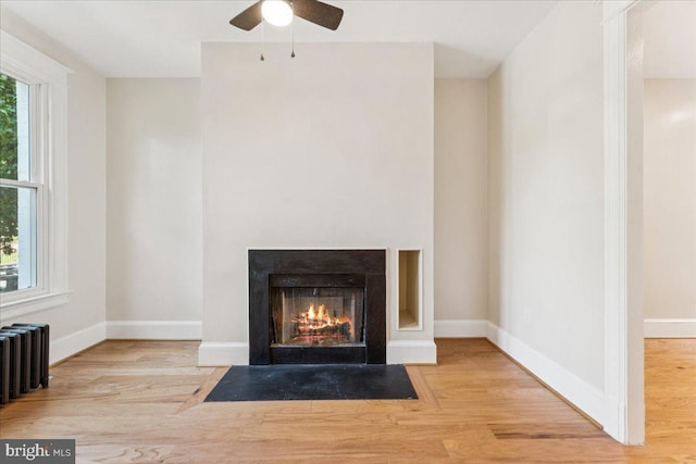 728 13th St SE, Washington, DC 20003 - detailed view of radiator heating unit, wood finished floors, ceiling fan, and a fireplace with flush hearth