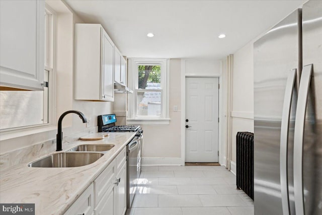 728 13th St SE, Washington, DC 20003 - kitchen with stainless steel appliances, under cabinet range hood, radiator heating unit, white cabinets, and light stone counters