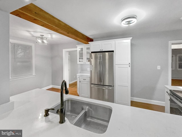 10811 Pearson St, Kensington, MD 20895 - kitchen featuring freestanding refrigerator, a sink, white cabinetry, beamed ceiling, and glass insert cabinets