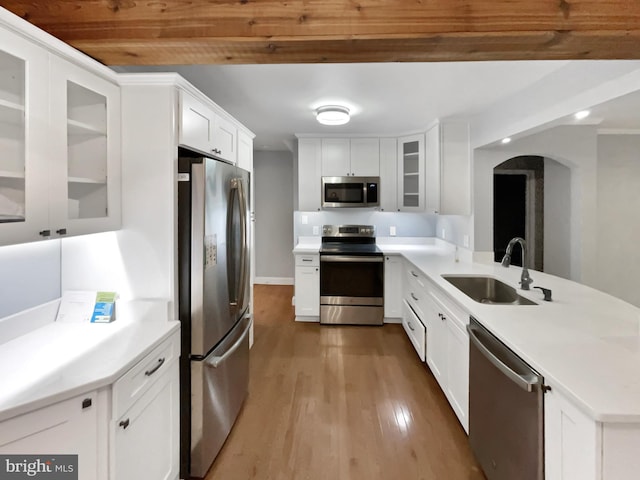 10811 Pearson St, Kensington, MD 20895 - kitchen featuring appliances with stainless steel finishes, a sink, a peninsula, arched walkways, and wood finished floors