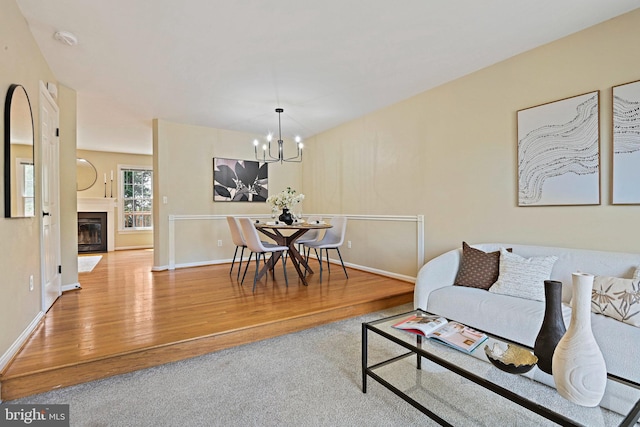 1205 Bond St, Herndon, VA 20170 - living room featuring wood finished floors, a chandelier, and a fireplace with flush hearth