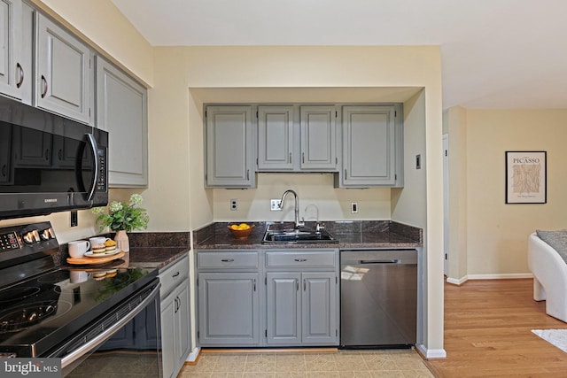 1205 Bond St, Herndon, VA 20170 - kitchen featuring dishwasher, black range with electric stovetop, gray cabinetry, dark stone counters, and light wood finished floors