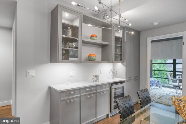 1300 4th St SE Unit 214, Washington, DC 20003 - bar area featuring wood finished floors, wine cooler, baseboards, and a chandelier