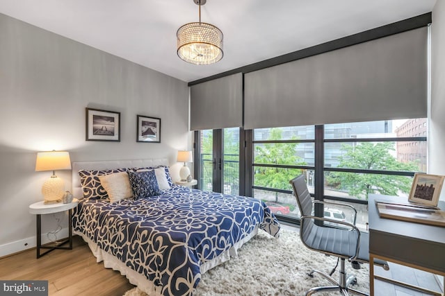 1300 4th St SE Unit 214, Washington, DC 20003 - bedroom with wood finished floors, a chandelier, and baseboards