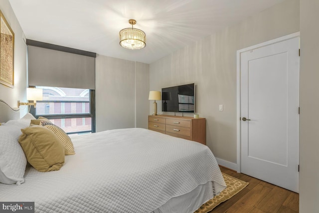 1300 4th St SE Unit 214, Washington, DC 20003 - bedroom featuring wood finished floors, baseboards, and a chandelier