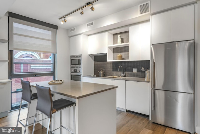 1300 4th St SE Unit 214, Washington, DC 20003 - kitchen with stainless steel appliances, a sink, plenty of natural light, and tasteful backsplash