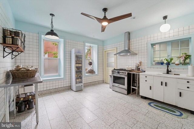 5811 Mcmahon St, Philadelphia, PA 19144 - kitchen featuring wall chimney exhaust hood, gas stove, a sink, tile walls, and ceiling fan