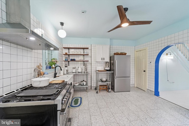 5811 Mcmahon St, Philadelphia, PA 19144 - kitchen featuring appliances with stainless steel finishes, tile walls, wall chimney range hood, dark speckled floor, and a ceiling fan
