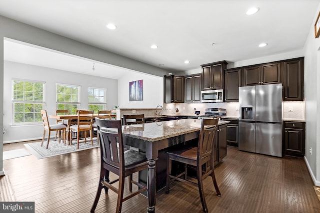 3615 Amber Way, Aberdeen, MD 21001 - kitchen featuring stainless steel appliances, a kitchen bar, dark wood-type flooring, dark brown cabinetry, and backsplash