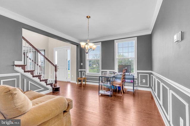 home office featuring crown molding, a chandelier, a decorative wall, hardwood / wood-style floors, and a wainscoted wall
