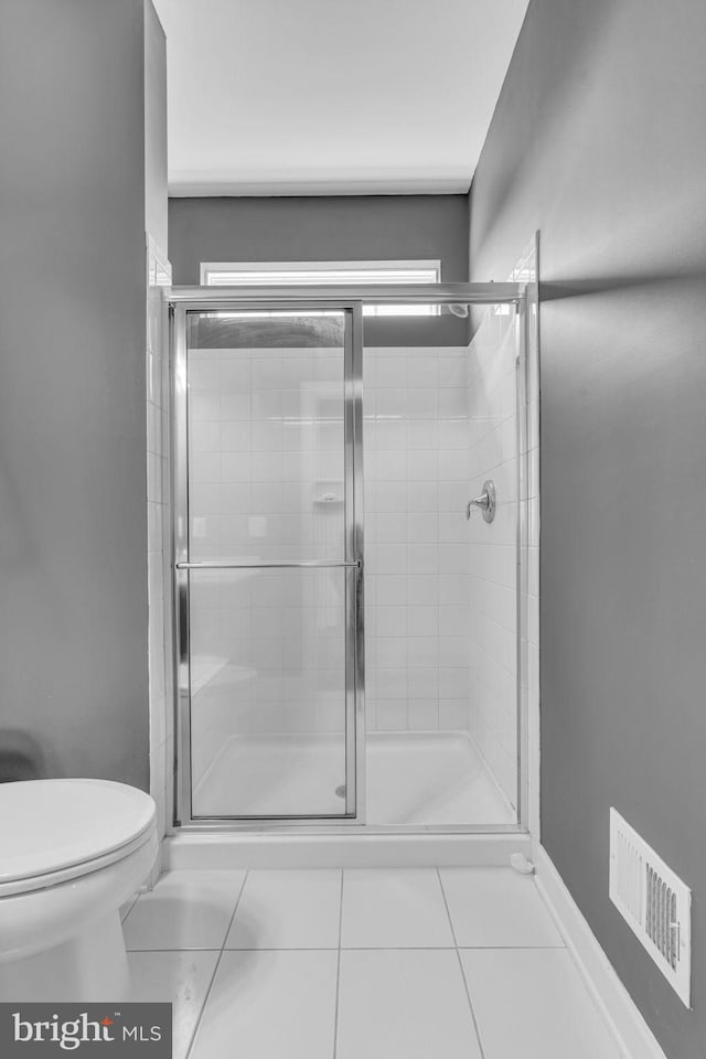 full bathroom with toilet, a shower stall, and tile patterned flooring