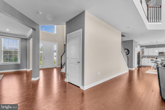 entrance foyer with stairway, dark wood-style floors, baseboards, plenty of natural light, and recessed lighting