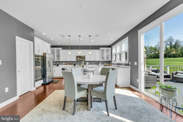 dining space with dark wood-style floors, baseboards, and recessed lighting
