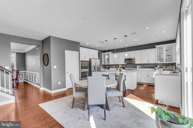 dining room featuring stairs, wood finished floors, recessed lighting, and baseboards