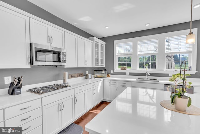 kitchen featuring appliances with stainless steel finishes, a sink, white cabinets, light countertops, and recessed lighting