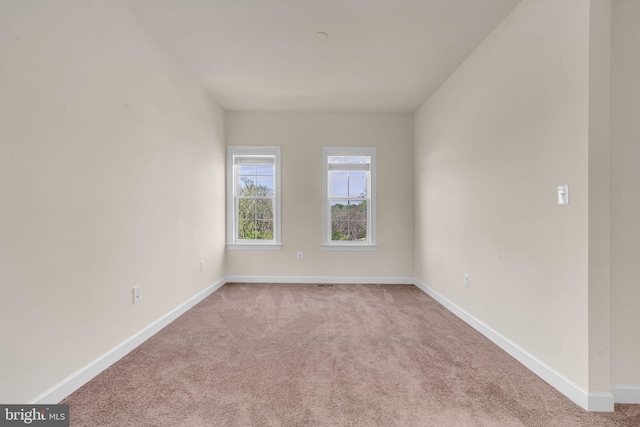 unfurnished room with carpet and baseboards