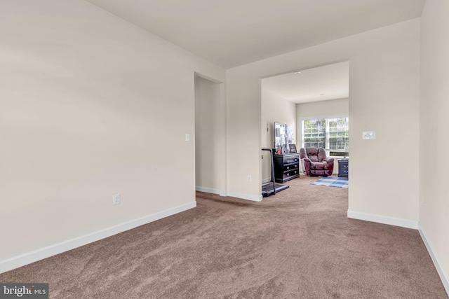carpeted empty room with baseboards