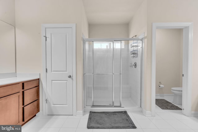 bathroom featuring a stall shower, toilet, tile patterned floors, and baseboards