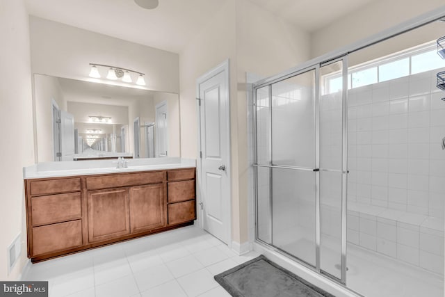 full bathroom featuring a stall shower, vanity, and tile patterned flooring