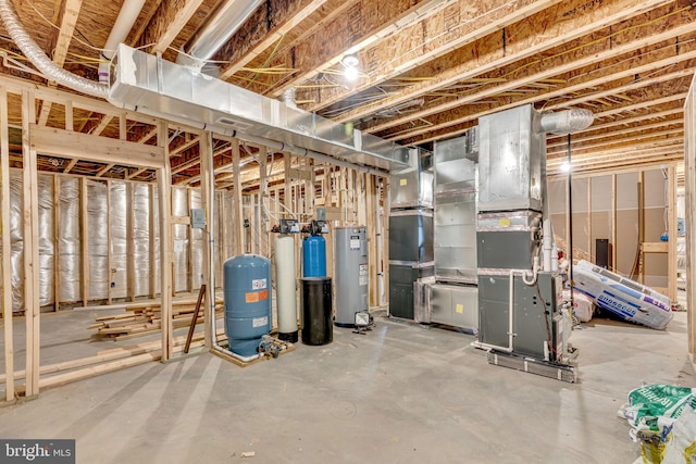 unfinished below grade area featuring electric water heater, a water pressure tank, and a water softener