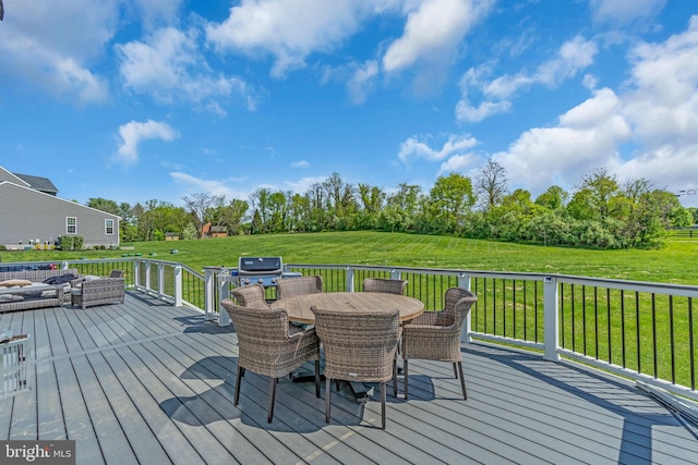 wooden deck featuring a yard, outdoor dining space, and view of wooded area