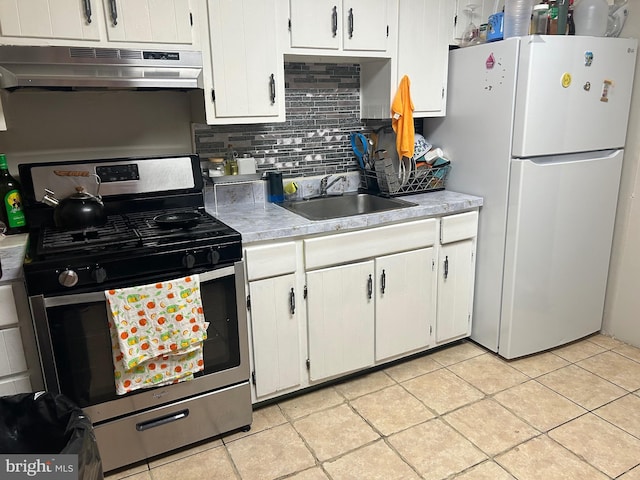 1110 Hamilton Ave, Trenton, NJ 08629 - kitchen featuring stainless steel range with gas stovetop, freestanding refrigerator, under cabinet range hood, a sink, and light countertops