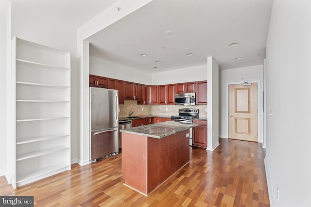 901 N Penn St Unit F1504, Philadelphia, PA 19123 - kitchen with appliances with stainless steel finishes, light wood-style flooring, backsplash, a sink, and a kitchen island