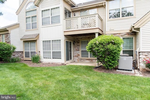 1615 Foxmeadow Cir Unit 1615, Royersford, PA 19468 - back of property with stone siding, central AC, a balcony, and a lawn