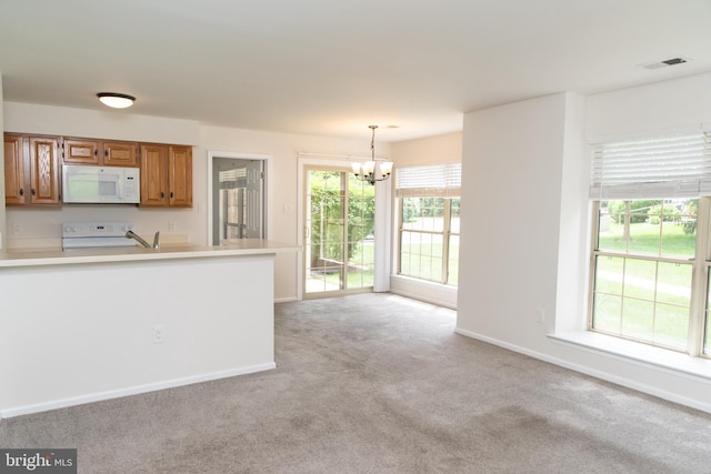 1615 Foxmeadow Cir Unit 1615, Royersford, PA 19468 - kitchen featuring white microwave, range, a chandelier, light colored carpet, and light countertops
