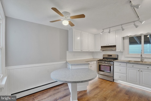 137 S Main St, Yoe, PA 17313 - kitchen featuring stainless steel gas range oven, a sink, a baseboard heating unit, under cabinet range hood, and rail lighting