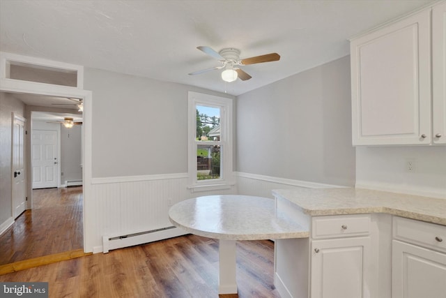 137 S Main St, Yoe, PA 17313 - unfurnished dining area featuring ceiling fan, a baseboard heating unit, a wainscoted wall, and light wood-style floors