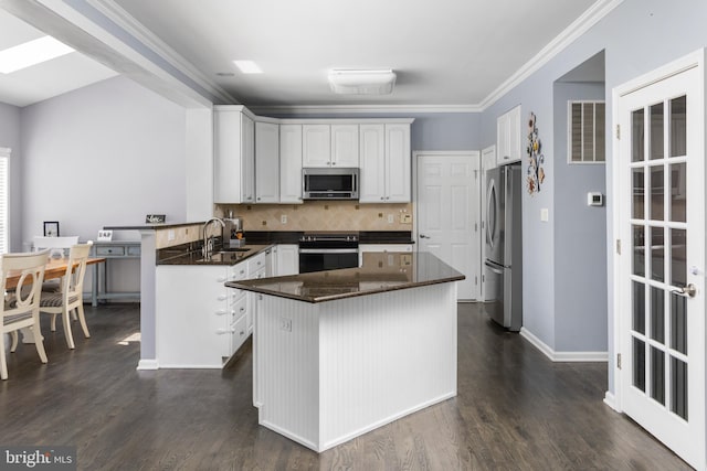 1781 Cobblestone Ln, Vineland, NJ 08361 - kitchen with appliances with stainless steel finishes, a peninsula, decorative backsplash, white cabinets, and dark wood-type flooring