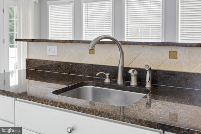 1781 Cobblestone Ln, Vineland, NJ 08361 - kitchen view of a sink, white cabinets, tasteful backsplash, and dark stone counters