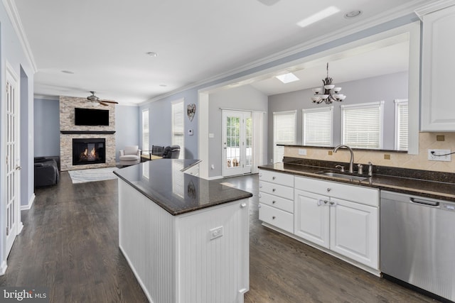 1781 Cobblestone Ln, Vineland, NJ 08361 - kitchen with stainless steel dishwasher, a sink, ornamental molding, a stone fireplace, and white cabinetry