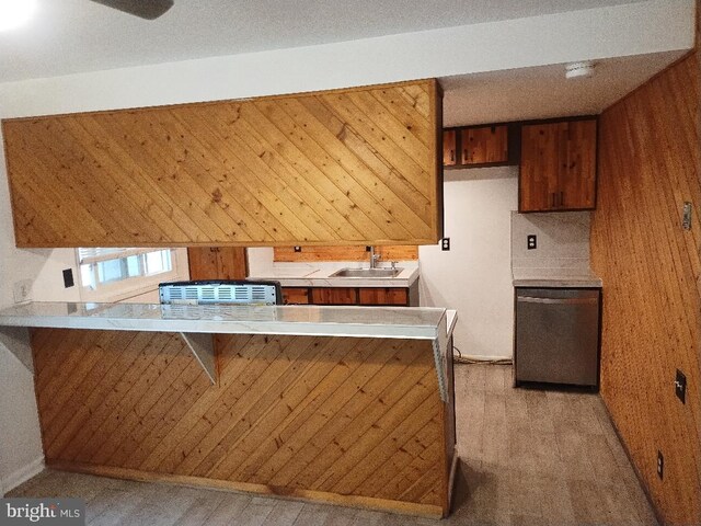 2841 Aquarius Ave, Silver Spring, MD 20906 - kitchen featuring light countertops, a peninsula, a sink, wood walls, and brown cabinetry