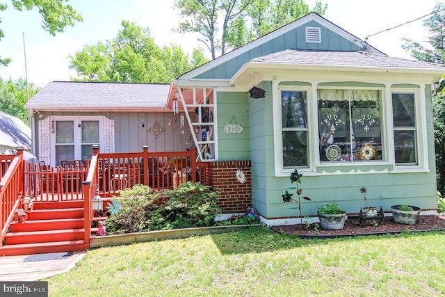 3552 Oak Dr, Edgewater, MD 21037 - view of front of house featuring a wooden deck, board and batten siding, a front yard, and a shingled roof