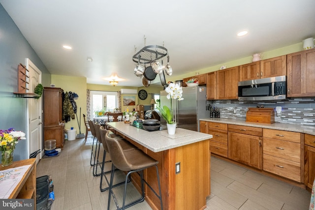 1341 Westview Xing, Grantsville, MD 21536 - kitchen featuring stainless steel appliances, brown cabinetry, decorative backsplash, a kitchen breakfast bar, and light countertops