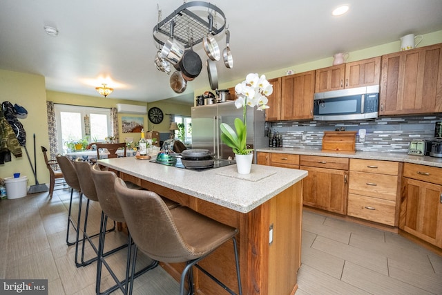 1341 Westview Xing, Grantsville, MD 21536 - kitchen with appliances with stainless steel finishes, a center island, brown cabinets, tasteful backsplash, and a breakfast bar area