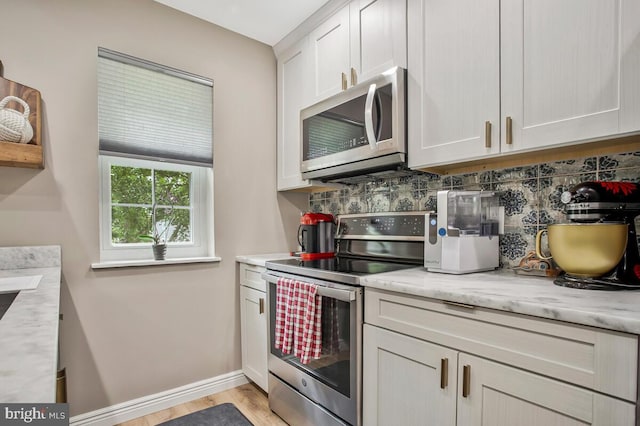 17 Edgewood Green Ct, Annapolis, MD 21403 - kitchen with appliances with stainless steel finishes, decorative backsplash, baseboards, light wood finished floors, and white cabinetry