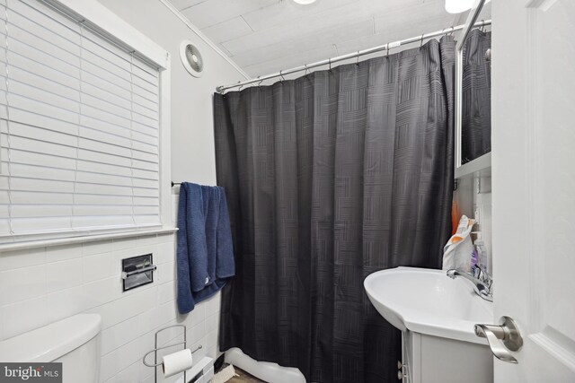 904 W Burke St, Martinsburg, WV 25401 - full bath featuring toilet, a shower with shower curtain, vanity, and tile walls