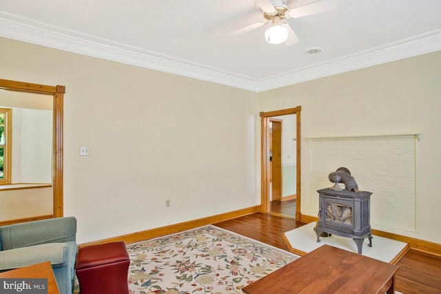 22350 Old Hundred Rd, Barnesville, MD 20838 - living room featuring a wood stove, crown molding, wood finished floors, ceiling fan, and baseboards