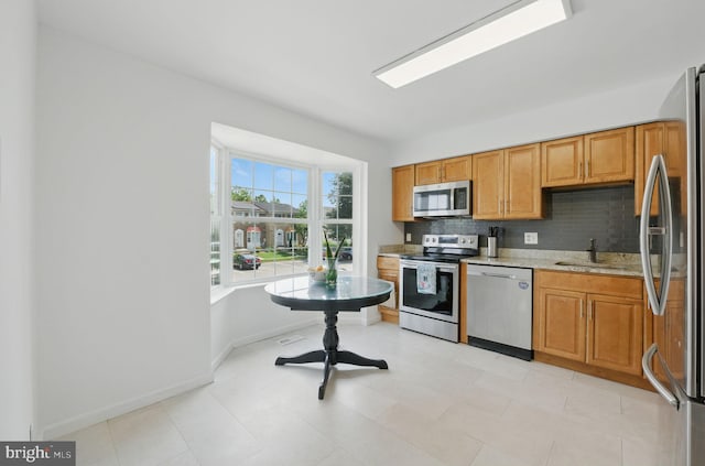 1252 Knoll Mist Ln, Gaithersburg, MD 20879 - kitchen with appliances with stainless steel finishes, backsplash, brown cabinets, and light stone countertops