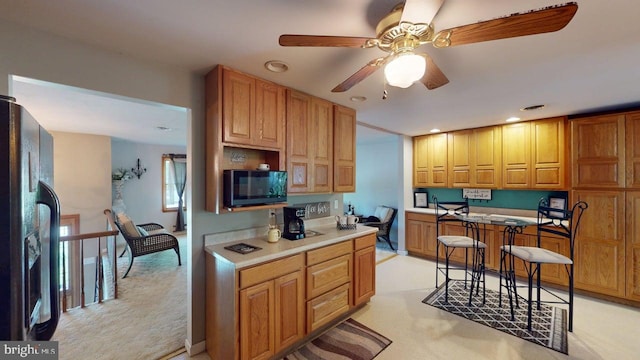 14701 Viewcrest Rd SW, Cresaptown, MD 21502 - kitchen with black fridge, a ceiling fan, light countertops, light colored carpet, and recessed lighting