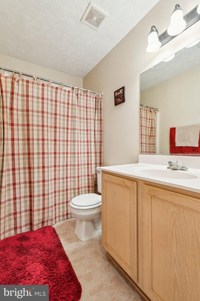 721 Canterbury Dr, Ruther Glen, VA 22546 - bathroom with toilet, vanity, and a textured ceiling