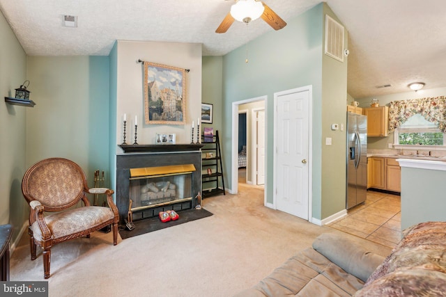 721 Canterbury Dr, Ruther Glen, VA 22546 - living room with a textured ceiling, a fireplace with flush hearth, a ceiling fan, light colored carpet, and baseboards