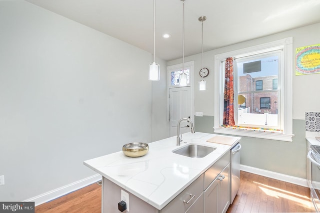 814 N Patterson Park Ave, Baltimore, MD 21205 - kitchen with a sink, baseboards, light wood-style floors, hanging light fixtures, and light stone countertops