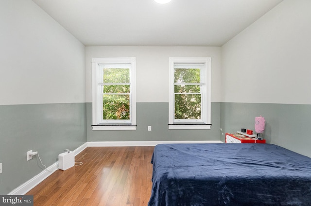 814 N Patterson Park Ave, Baltimore, MD 21205 - bedroom featuring multiple windows, wood finished floors, and baseboards
