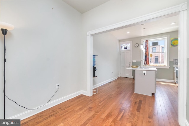814 N Patterson Park Ave, Baltimore, MD 21205 - kitchen with light wood-style flooring, light countertops, a sink, and baseboards